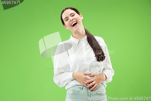 Image of The happy business woman standing and smiling against green background.