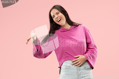 Image of The happy business woman standing and smiling against pink background.