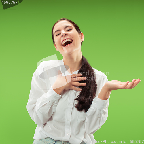 Image of The happy business woman standing and smiling against green background.