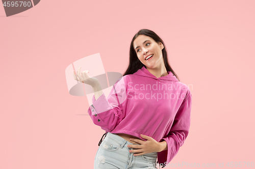 Image of The happy business woman standing and smiling against pink background.