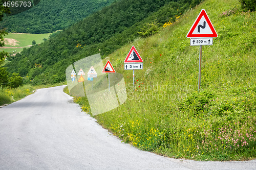 Image of some street signs on a steep road