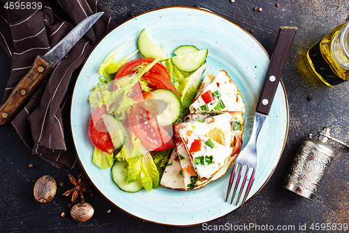 Image of omelette with vegetables on white plate