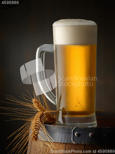 Image of beer jug on old wooden barrel