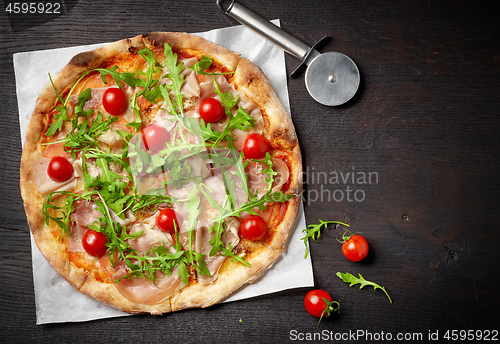 Image of freshly baked pizza on dark wooden table