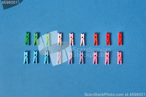 Image of Two lines of colorful clothespins with shadows.