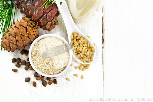 Image of Flour cedar in bowl and nuts in spoon on light board top