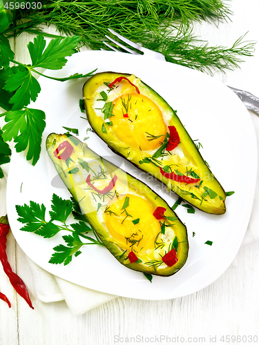 Image of Scrambled eggs with peppers in avocado on light board top