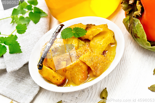 Image of Persimmons baked with honey in dish on board