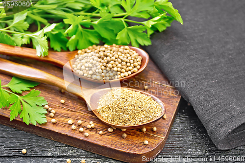Image of Coriander ground and seeds in two spoons on wooden board