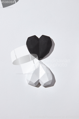 Image of Two gypsum hearts black and white with shadows.