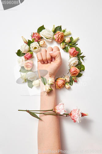 Image of Fresh natural flowers wreath with female\'s hand.