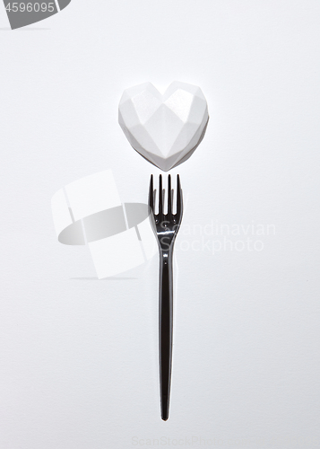 Image of Black plaster fork with gypsum white heart .