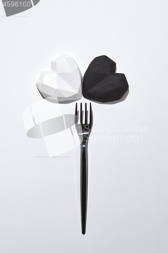 Image of Plaster fork with two gypsum hearts white and black.