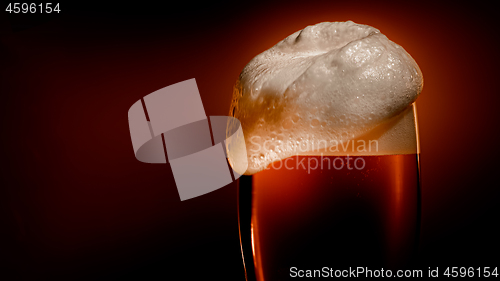 Image of Lager beer settles in the glass with a white cap of foam