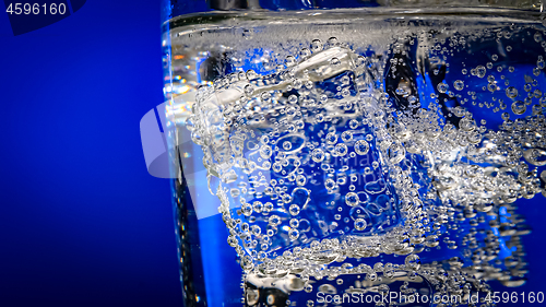 Image of Glass of water with ice on a dark blue background