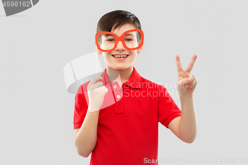 Image of smiling boy with big paper glasses showing peace