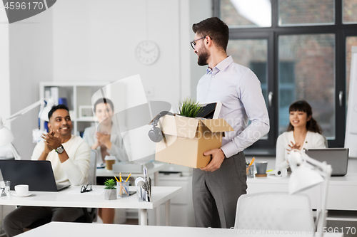 Image of office workers applauding to male colleague