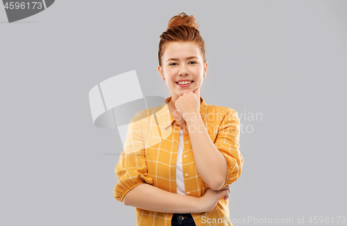 Image of smiling red haired teenage girl in checkered shirt