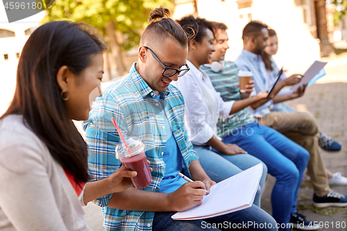 Image of group of happy students with notebook and drinks