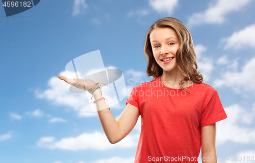 Image of smiling teenage girl holding empty hand