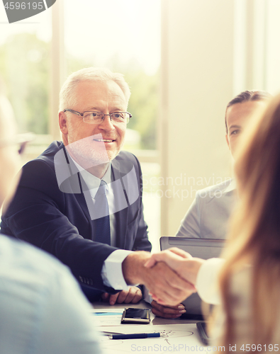 Image of senior businessman making handshake at office