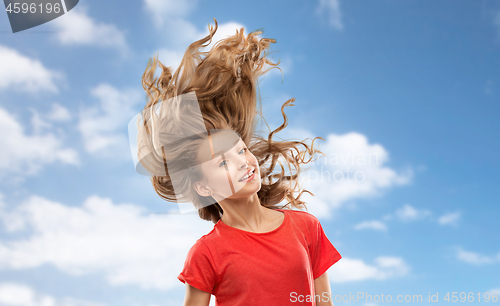 Image of smiling teenage girl in red with long wavy hair