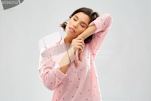 Image of happy woman in pajama making sleeping gesture