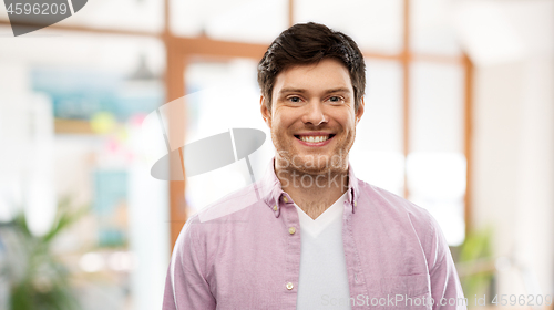 Image of smiling young man over office room background