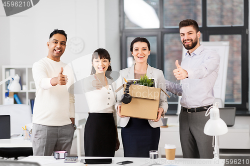 Image of new office worker and colleagues showing thumbs up