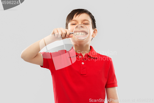 Image of boy showing his teeth through magnifying glass