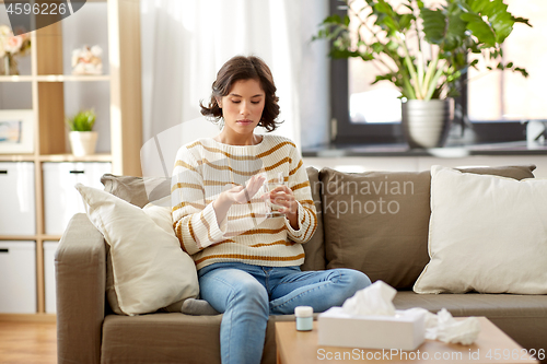 Image of sick woman taking medicine with water at home