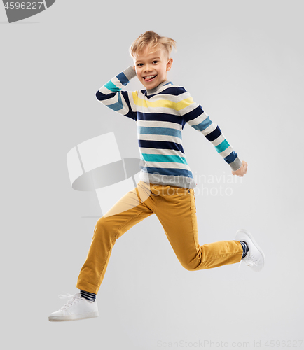 Image of happy little boy jumping and having fun