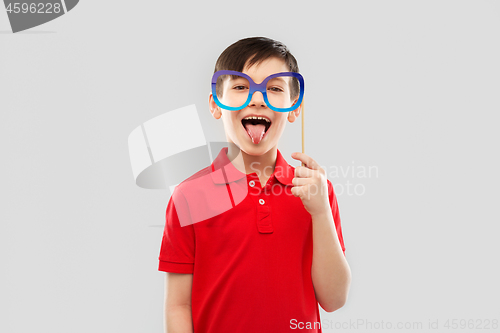 Image of happy boy with big paper glasses showing tongue