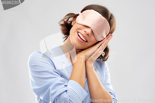 Image of happy young woman in pajama and eye sleeping mask