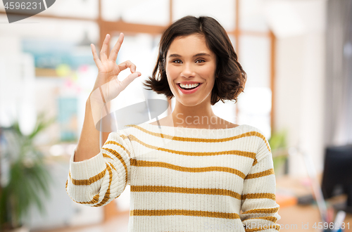 Image of happy smiling woman in striped pullover showing ok