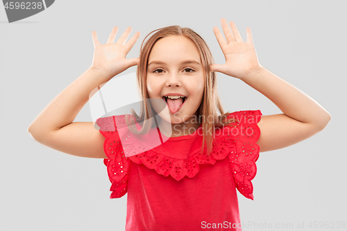 Image of funny girl showing her tongue and making big ears