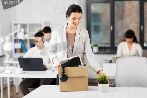 Image of happy businesswoman with personal stuff at office