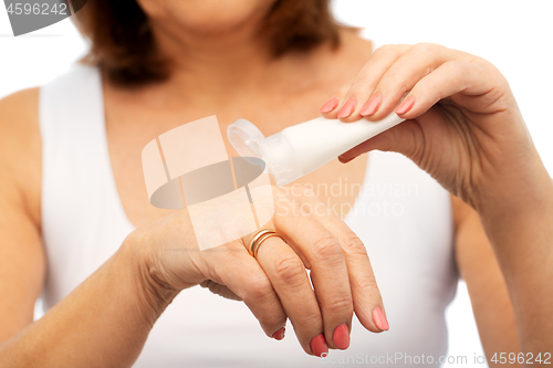 Image of close up of senior woman applying hand cream