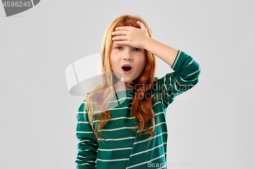 Image of shocked red haired girl holding to her head