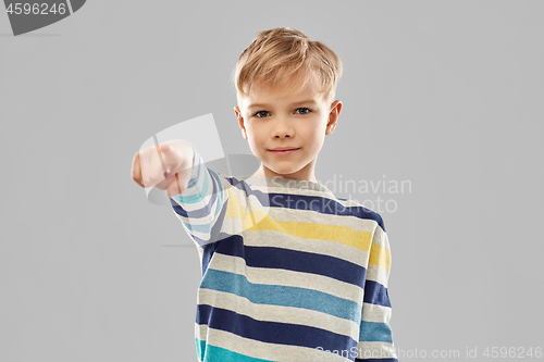 Image of smiling boy in striped pullover pointing finger