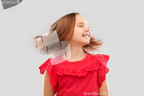 Image of happy girl in red shirt with waving hair