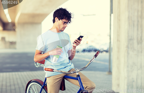 Image of man with smartphone and earphones on bicycle