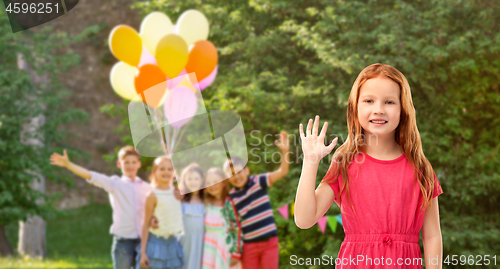 Image of red haired girl waving hand at birthday party