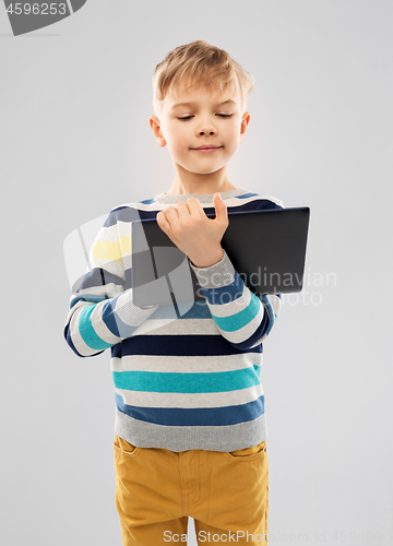 Image of boy in striped pullover with tablet pc computer