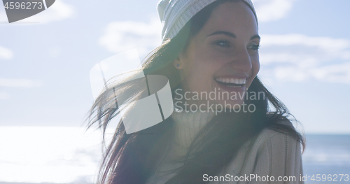 Image of Girl In Autumn Clothes Smiling on beach
