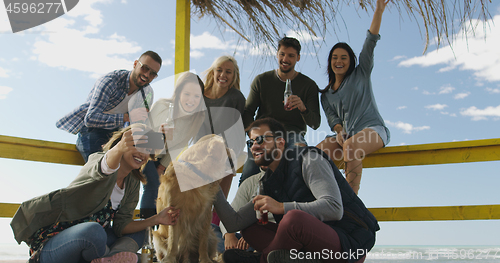 Image of Group of friends having fun on autumn day at beach