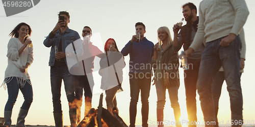 Image of Friends having fun at beach on autumn day