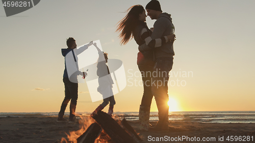 Image of Friends having fun at beach on autumn day