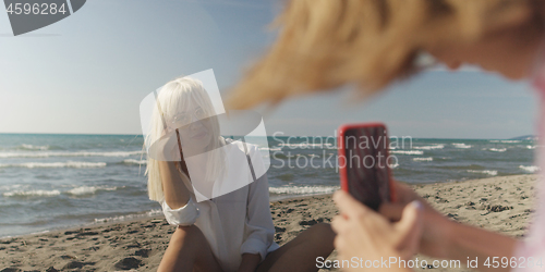 Image of Two girl friends having fun photographing each other on vecation