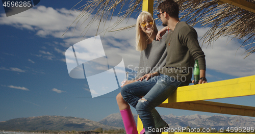 Image of Couple drinking beer together at the beach